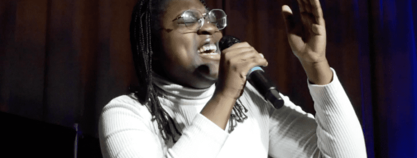 Person singing passionately into a microphone.